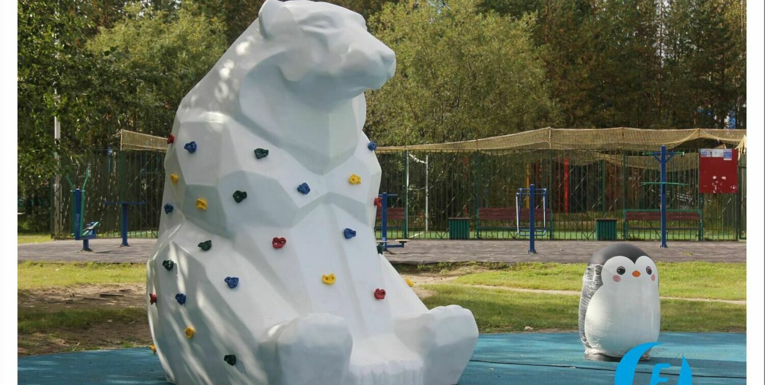 Скульптура медведя-скалодрома с фигурами пингвинов