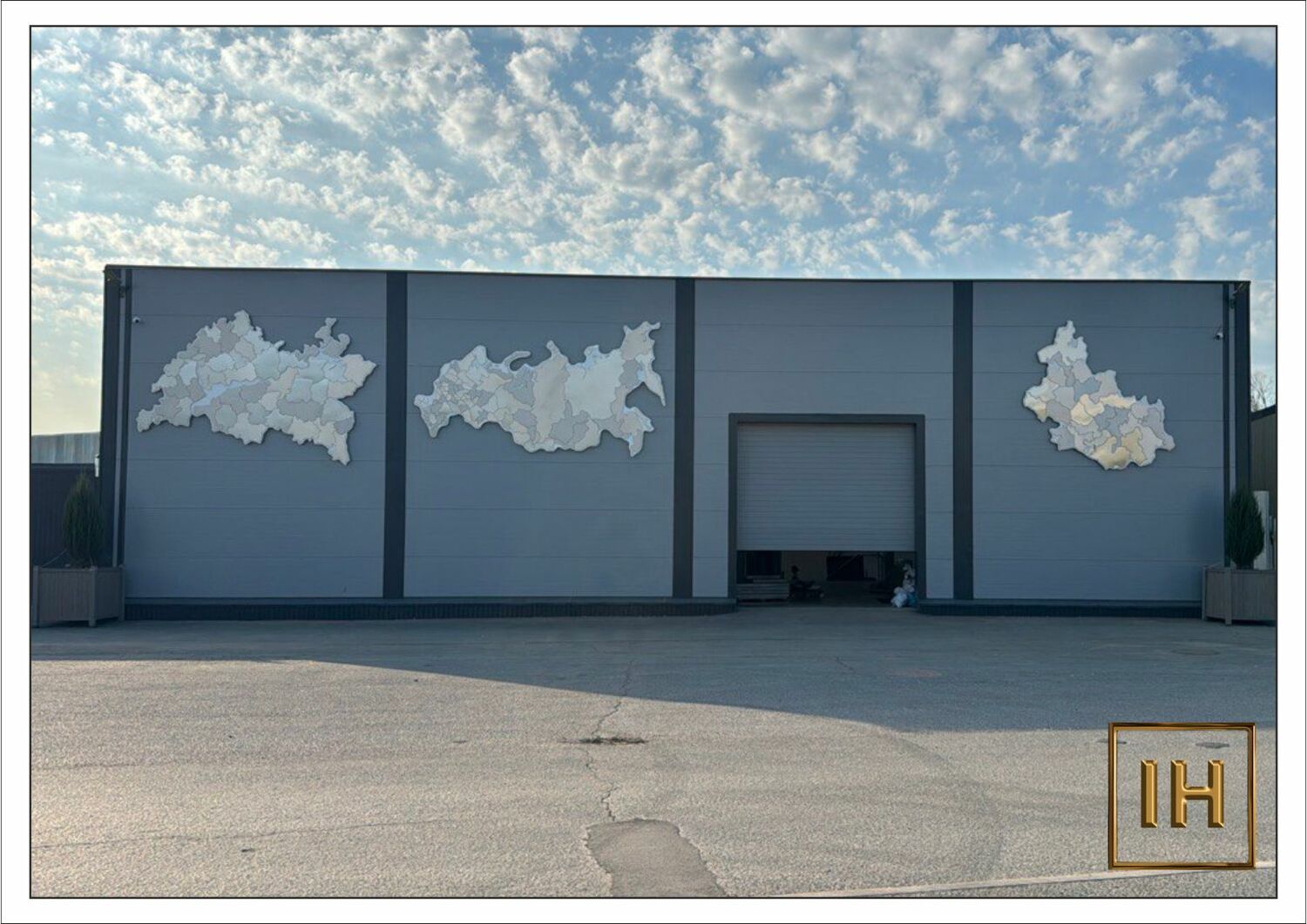 композиция карт из нержавеющей стали на фасаде днем