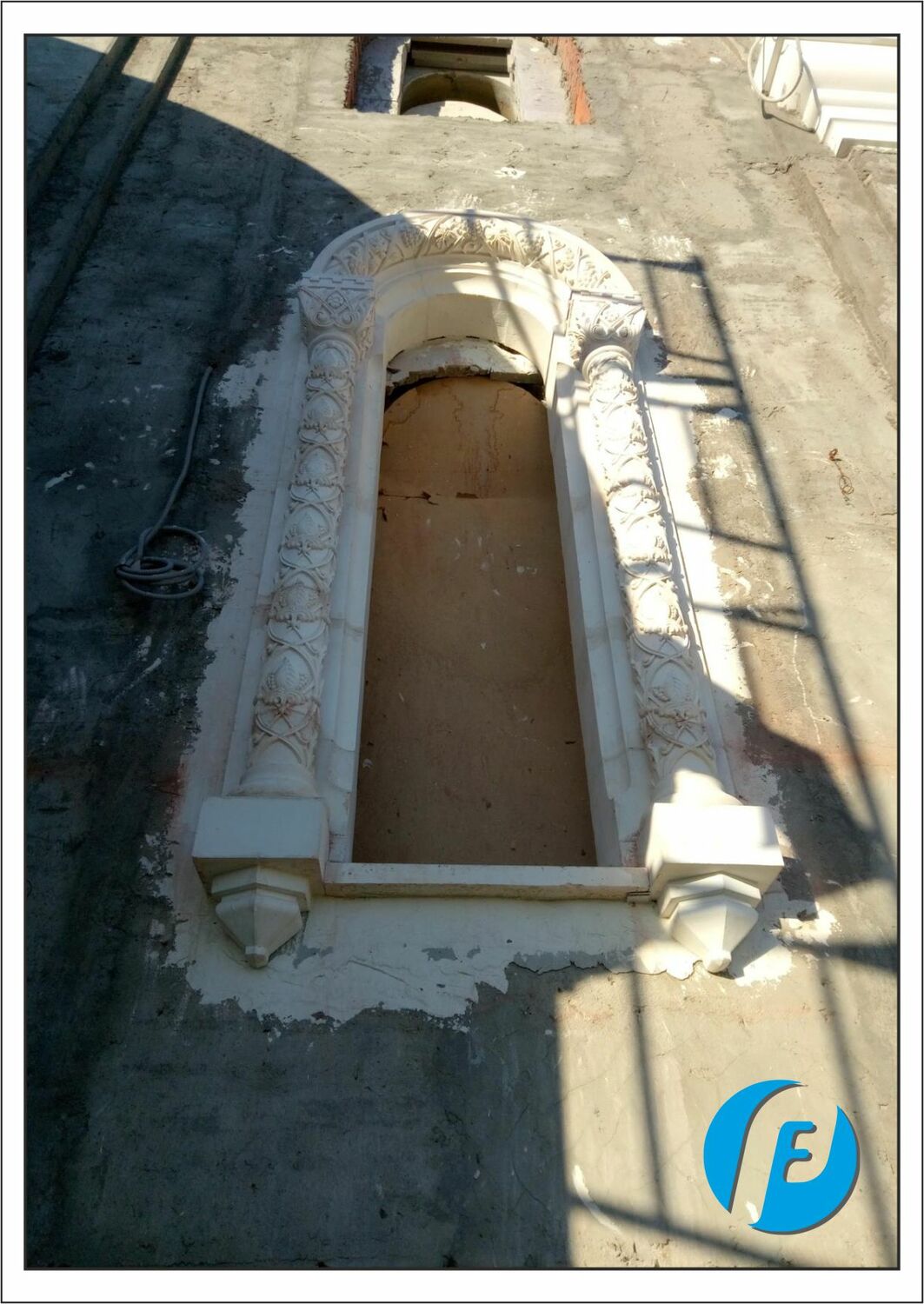 Крупный план оконного декора Детальный вид смонтированного оконного обрамления из архитектурного бетона с растительным орнаментом на фасаде храма.