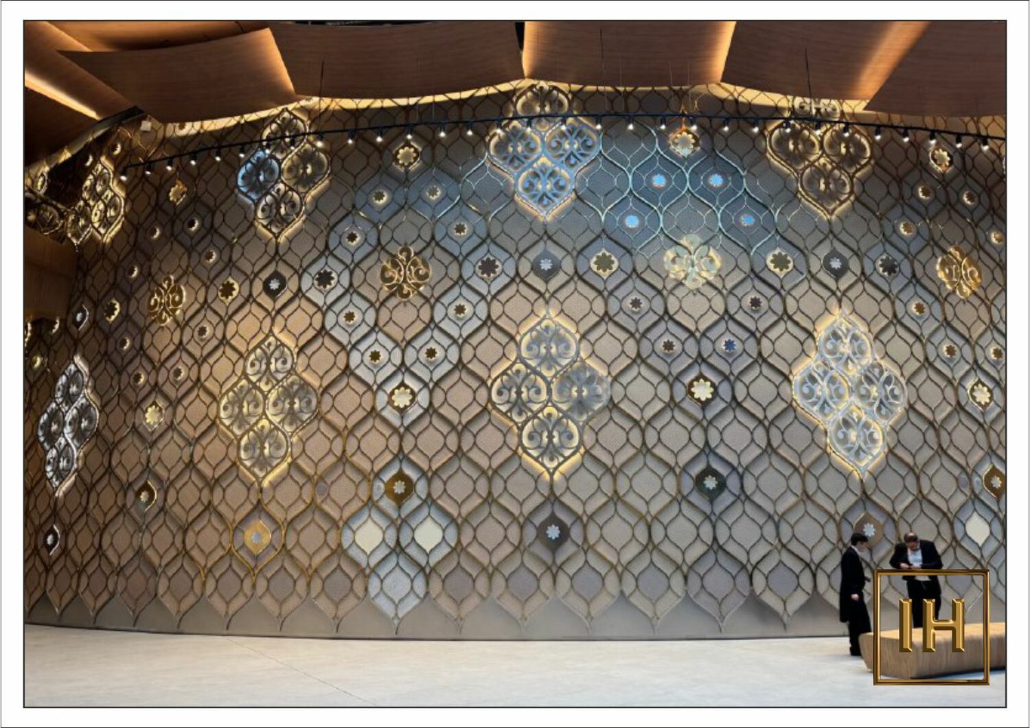 Масштаб панно в театре Камала Посетитель у подножия 13-метрового художественного панно с золотым покрытием в театре Камала, демонстрация масштаба.