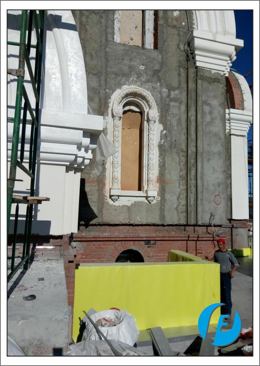 Готовое оконное обрамление на фасаде Смонтированное обрамление окна храма из белого бетона: капители, колонна, база, радиусная арка с резным орнаментом.