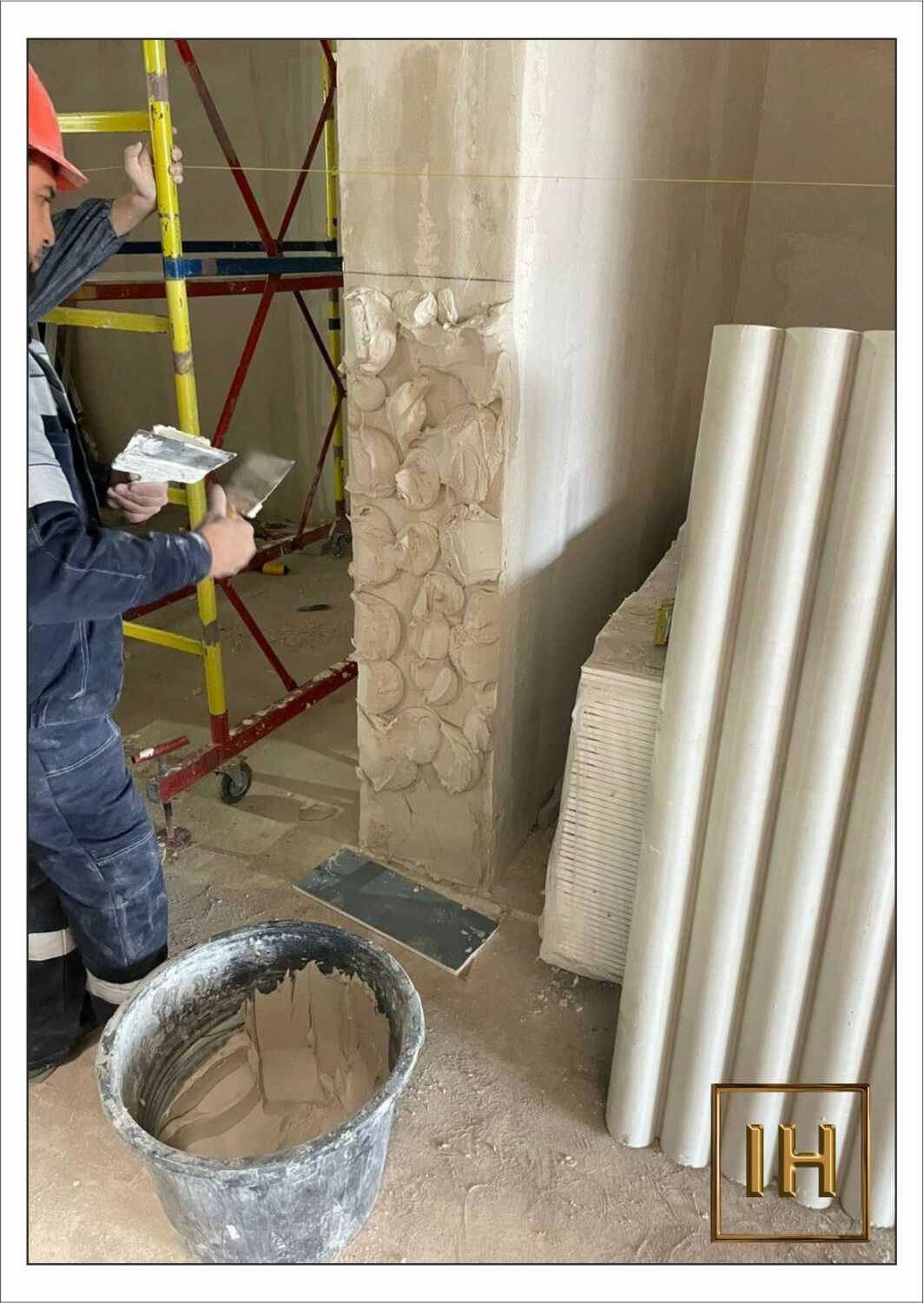 Процесс нанесения клея на гипсовую 3D панель перед монтажом на стену	